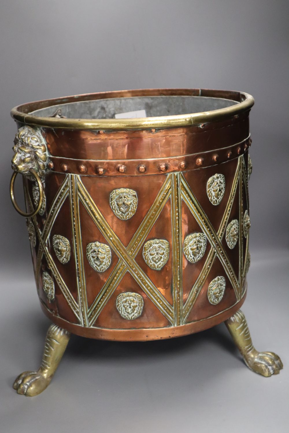 A Victorian copper and brass cylindrical coal box, with lion-mask ring handles, wood liner, 38cm